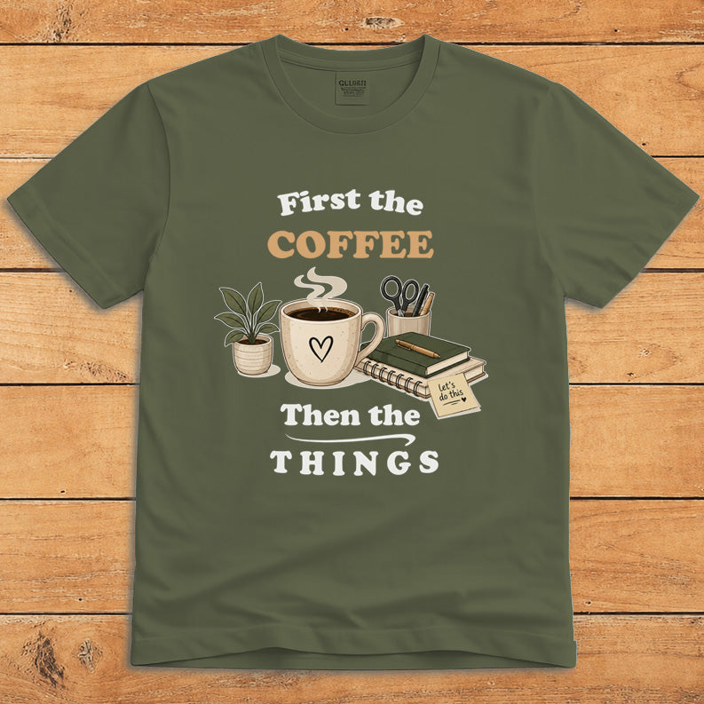 Military green coffee T-shirt with a steaming mug and the words “First the Coffee, Then the Things”