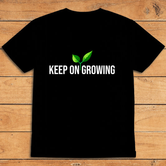 Black plant lover T-shirt featuring a green sprout and the words “Keep on Growing”