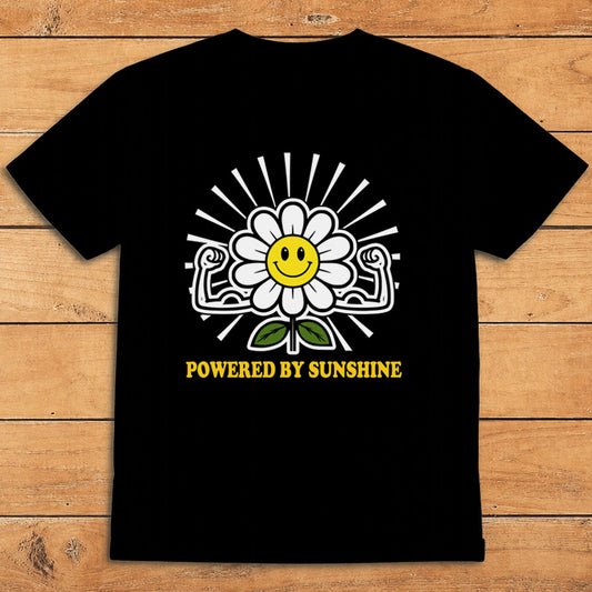 Black sunshine T-shirt featuring a smiling daisy flexing its arms and the words “Powered by Sunshine”