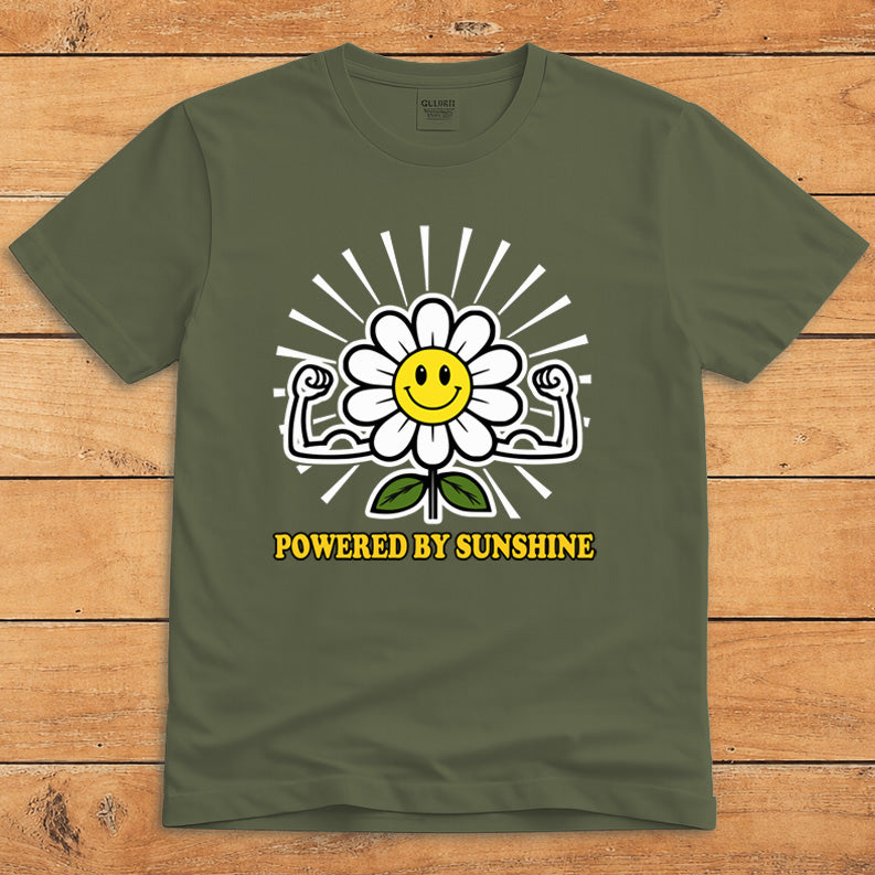 Military green sunshine T-shirt featuring a smiling daisy flexing its arms and the words “Powered by Sunshine”