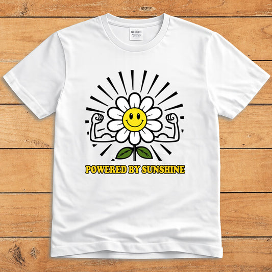 White sunshine T-shirt featuring a smiling daisy flexing its arms and the words “Powered by Sunshine”